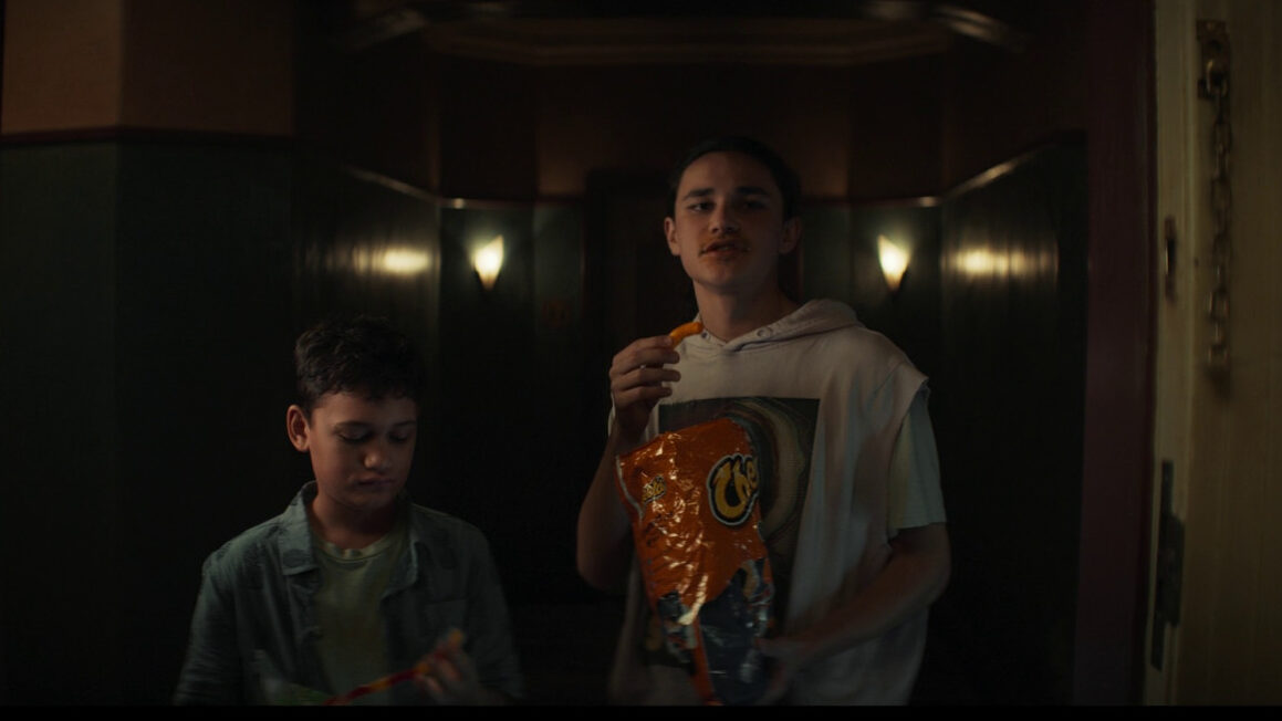 Characters eating Cheetos Puffs in Evil Dead Rise